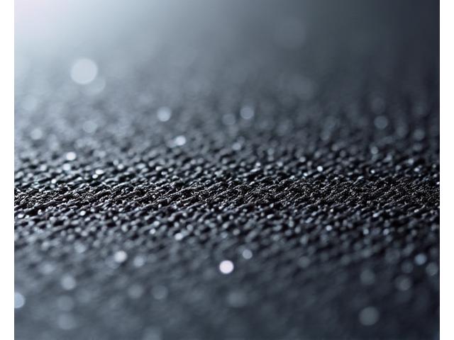 炭素繊維とガラス繊維が複合的に織り上げられた、工業製品のような精密なテキスタイル。高性能がうかがえる。