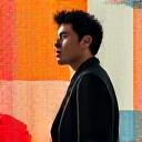 現代的なテキスタイルアート作品の前でポーズをとる若手男性アーティスト、創造的な表情